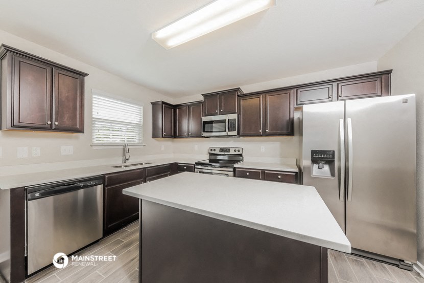 a kitchen with stainless steel appliances and a white counter top