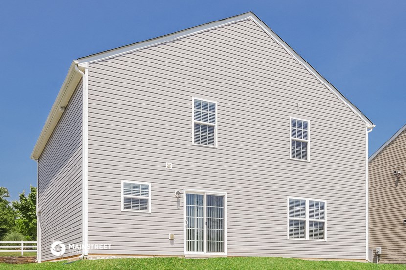 a white house with white siding and a blue sky