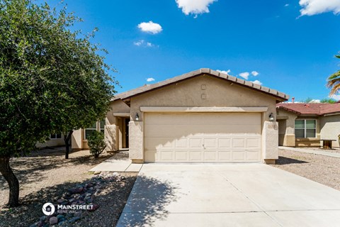 a house with a garage door and a tree