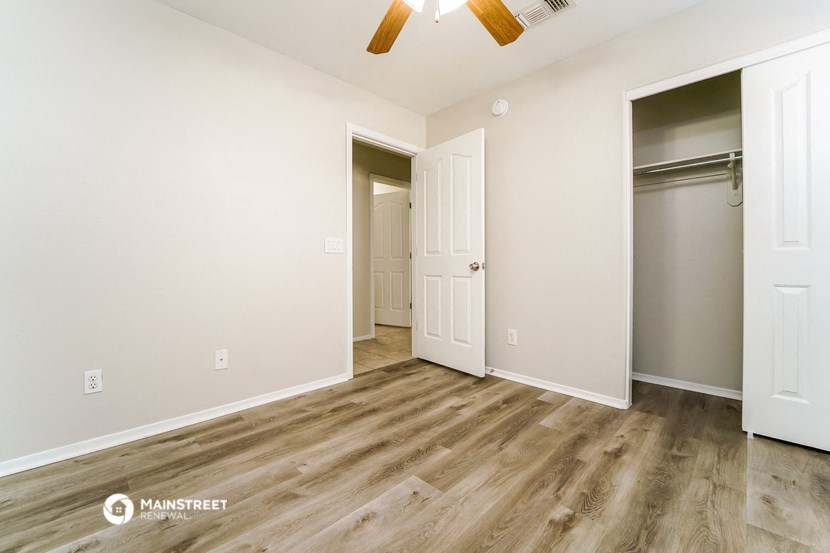 an empty room with a closet and a ceiling fan