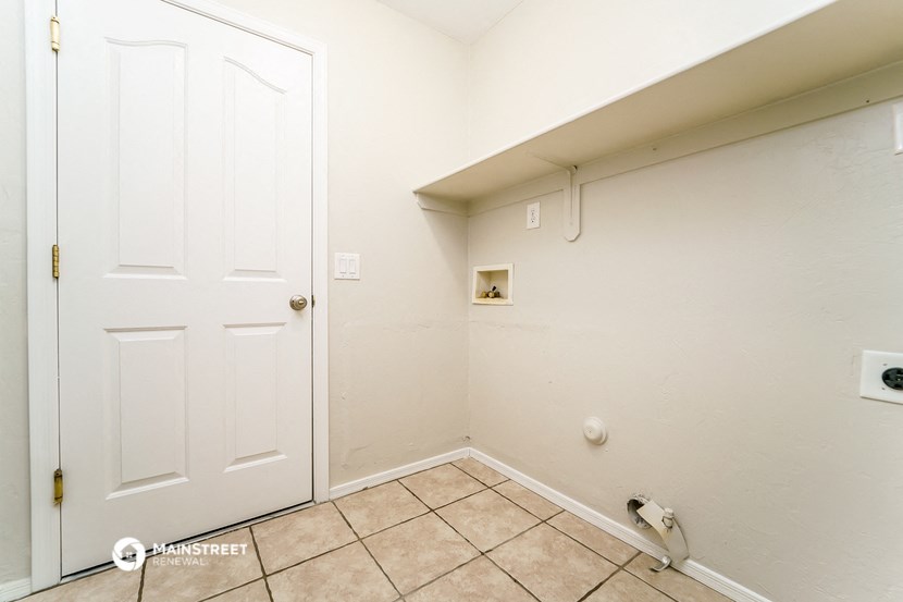 a bathroom with a white door and a tiled floor