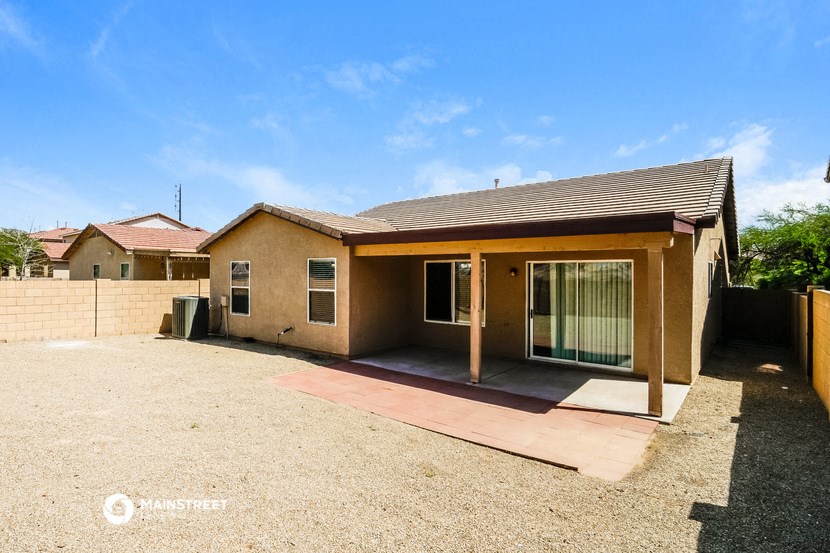 a small brick house with a driveway and a patio
