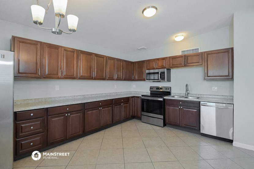 a large kitchen with wooden cabinets and stainless steel appliances