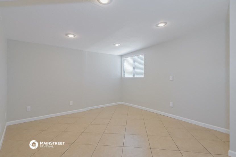 an empty room with a tiled floor and a window