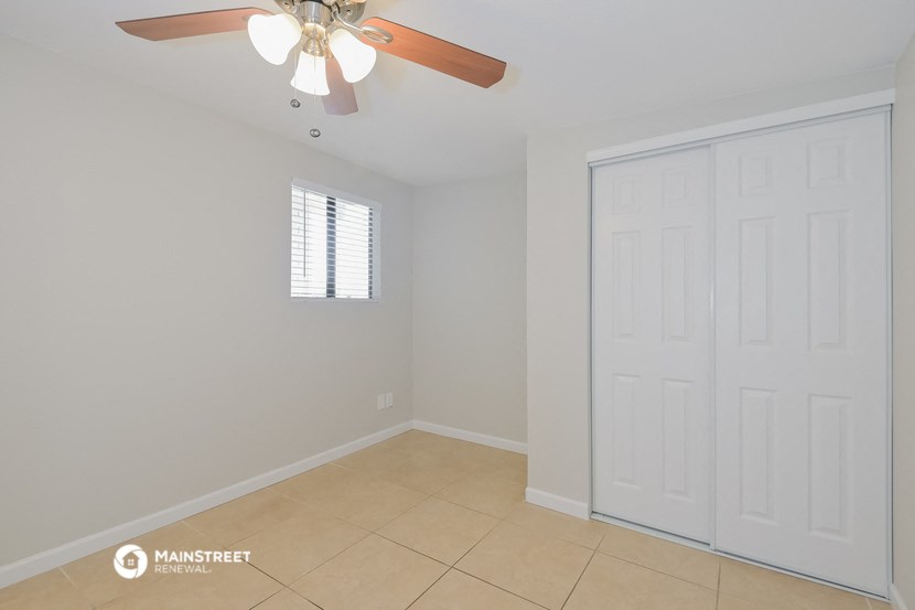 an empty room with a ceiling fan and a closet
