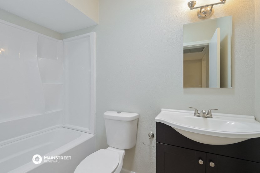a bathroom with a toilet and a sink and a bath tub