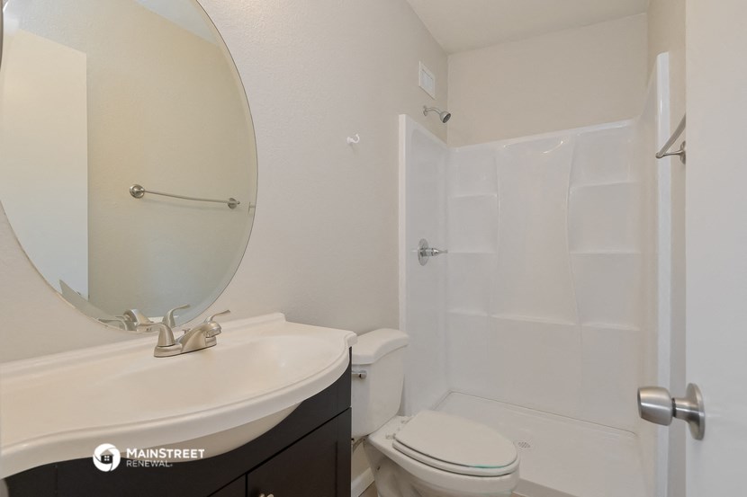 a bathroom with a toilet and a sink and a shower