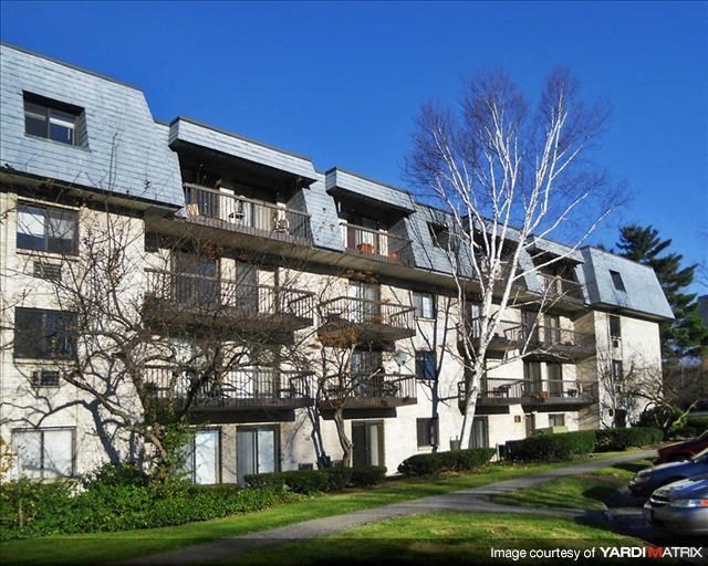 a large apartment building with trees in front of it