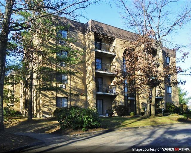 a large apartment building with trees in front of it