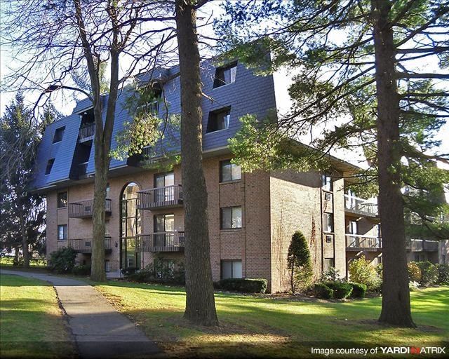 an apartment building with trees in front of it