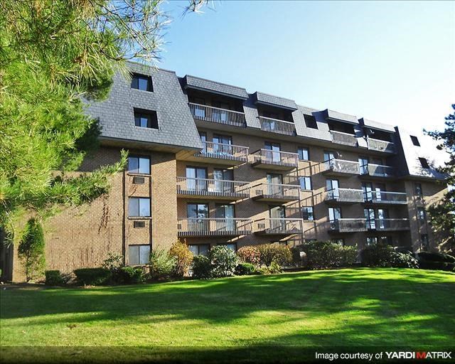 a large apartment building with a green yard