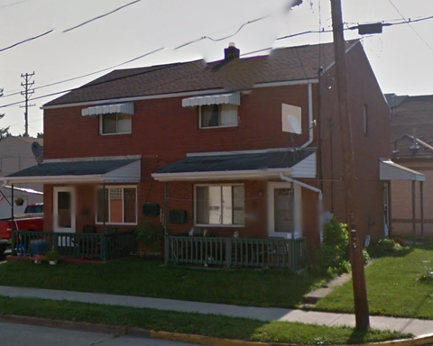 a red house with a porch and a white fence