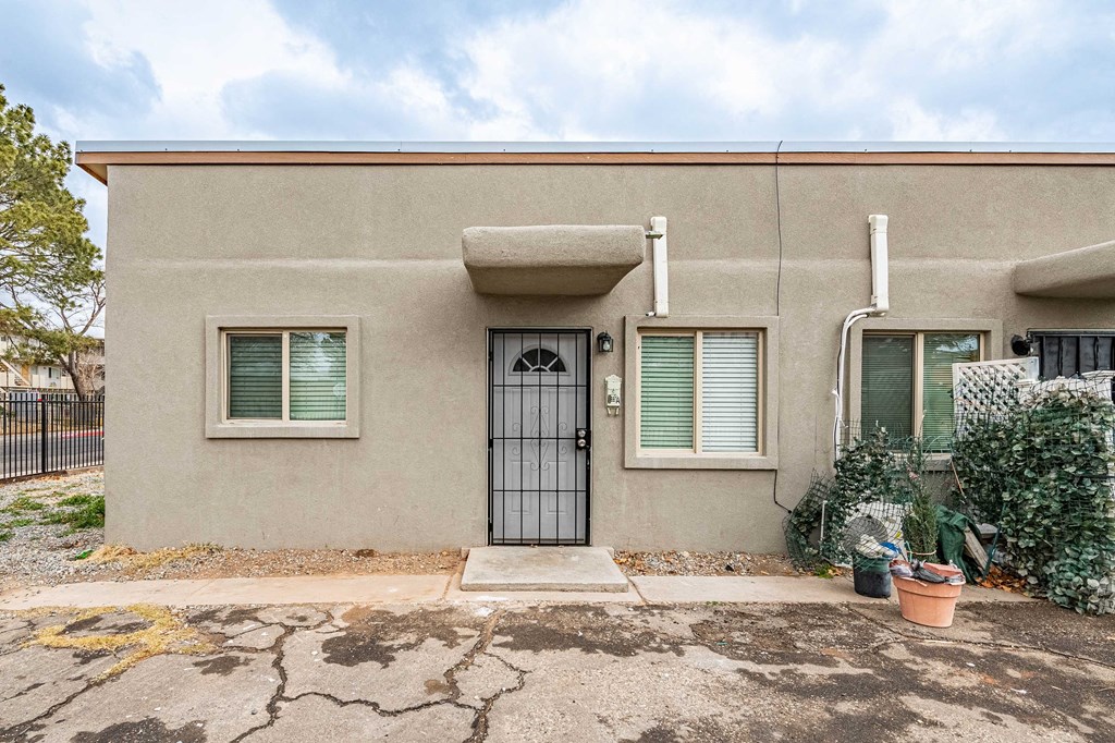 the front of a house with a door and two windows