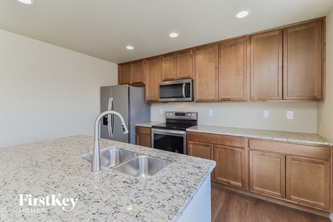 A kitchen with wooden cabinets and a granite countertop.