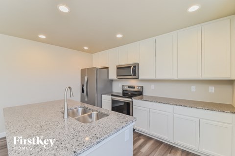 A kitchen with a granite countertop and stainless steel appliances.