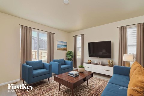 A living room with blue chairs and a brown coffee table.