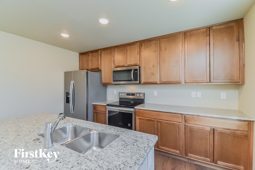 A kitchen with wooden cabinets and a granite countertop.