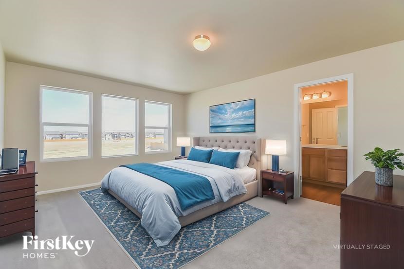 A bedroom with a large bed and a painting on the wall.