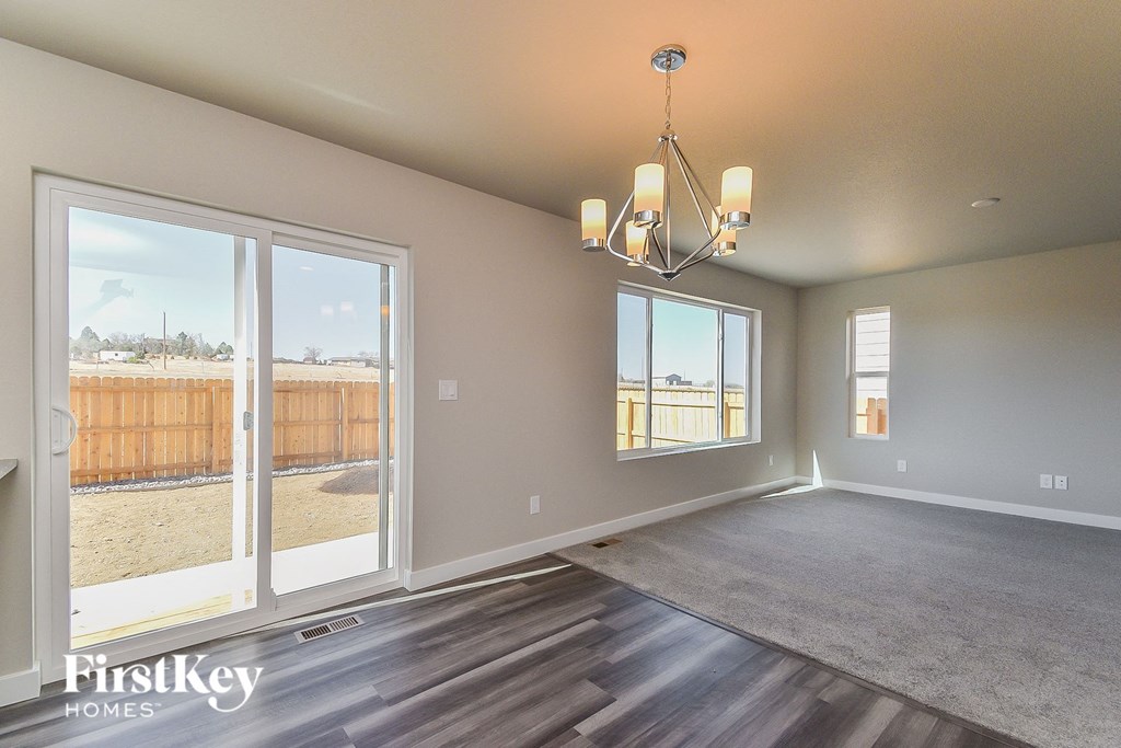 a living room with large windows and a chandelier
