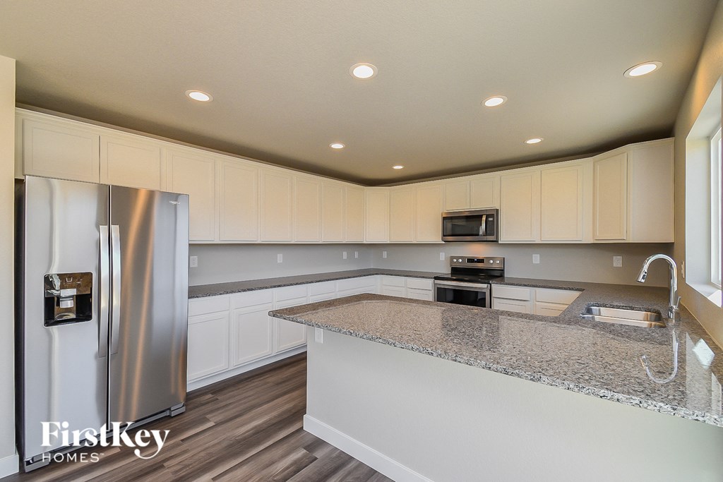 a kitchen with white cabinets and a granite counter top