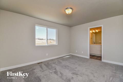 a bedroom with a carpeted floor and a large window