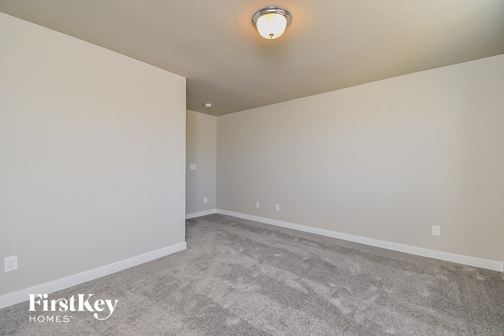 a empty living room with carpet and white walls