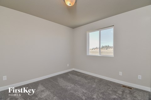 the living room of a house with carpet and a window