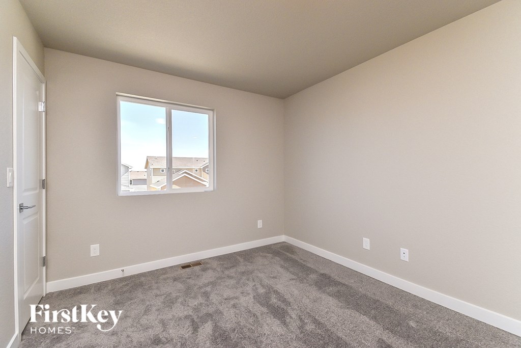 an empty room with carpet and a window