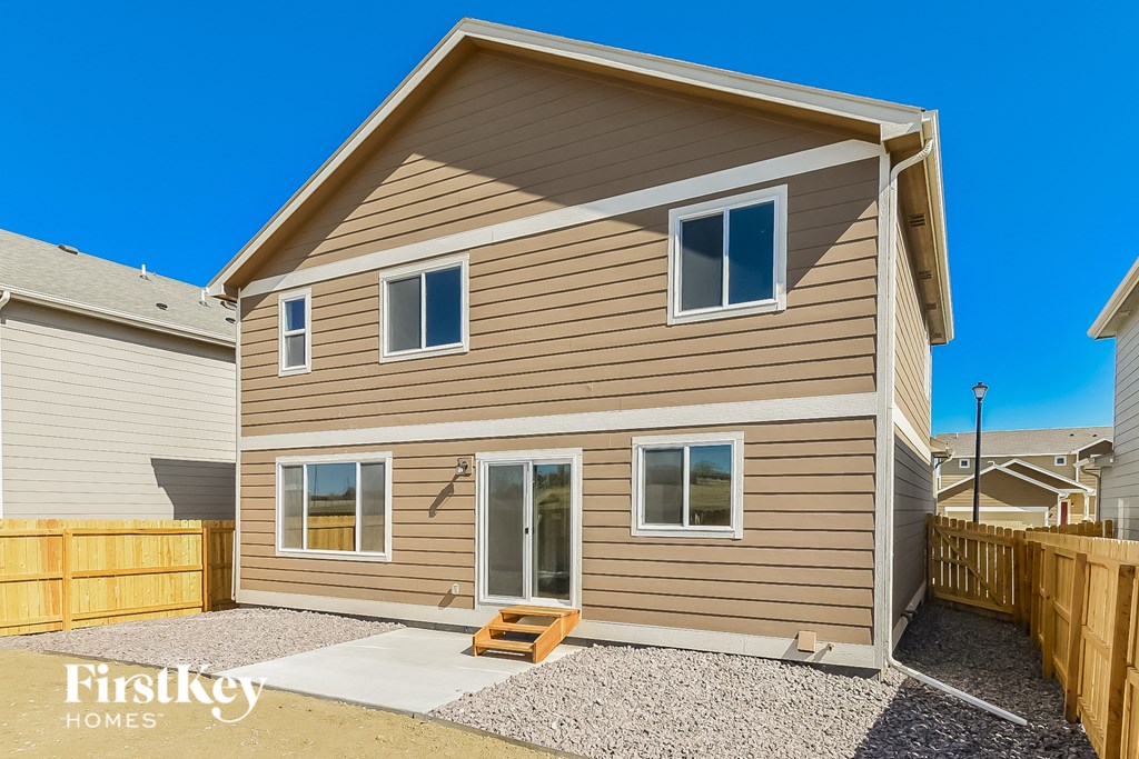 a tan and brown house with a wooden fence