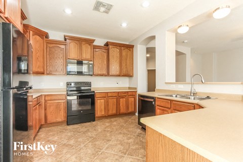 a kitchen with wooden cabinets and black appliances