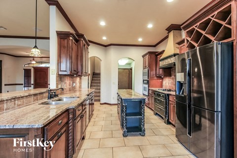 A kitchen with a black refrigerator and wooden cabinets.