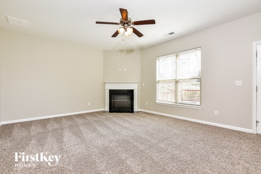the living room has a fireplace and a ceiling fan