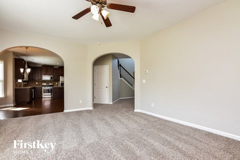 a living room with carpet and a ceiling fan