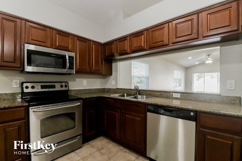 A kitchen with brown cabinets and stainless steel appliances.