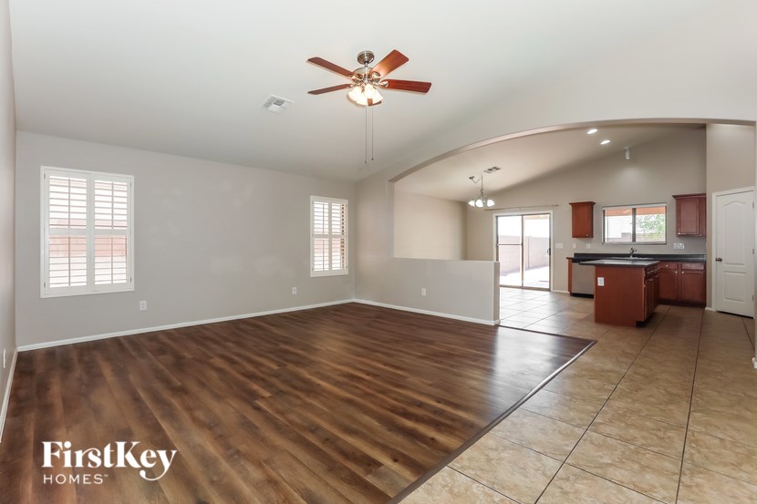 A spacious room with a ceiling fan and wooden flooring.