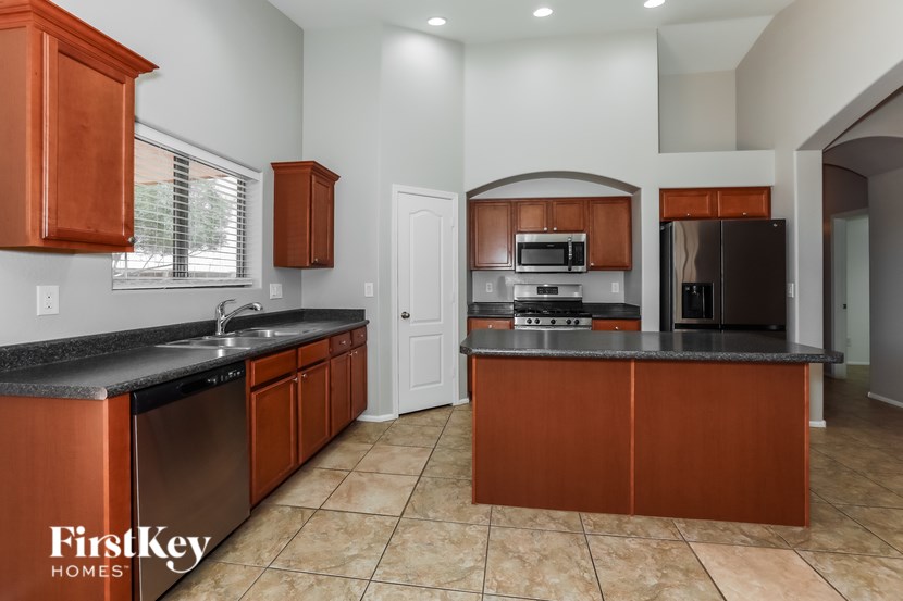 A kitchen with brown cabinets and a black countertop.