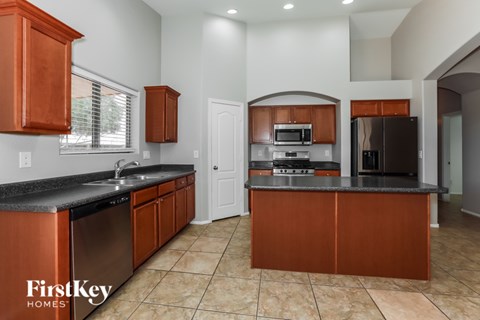 A kitchen with brown cabinets and a black countertop.