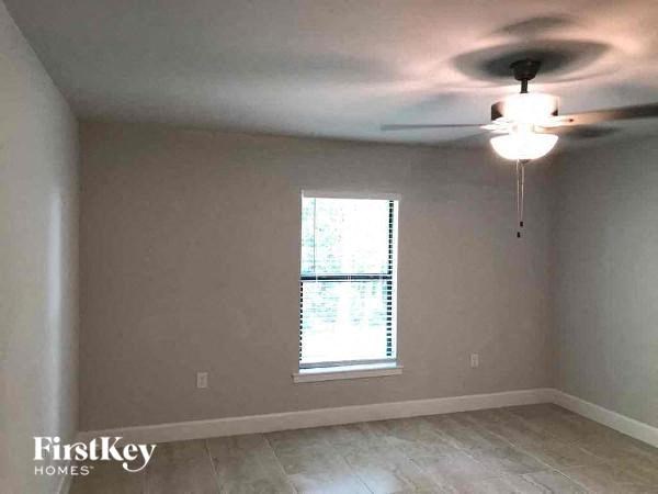 an empty room with a ceiling fan and a window