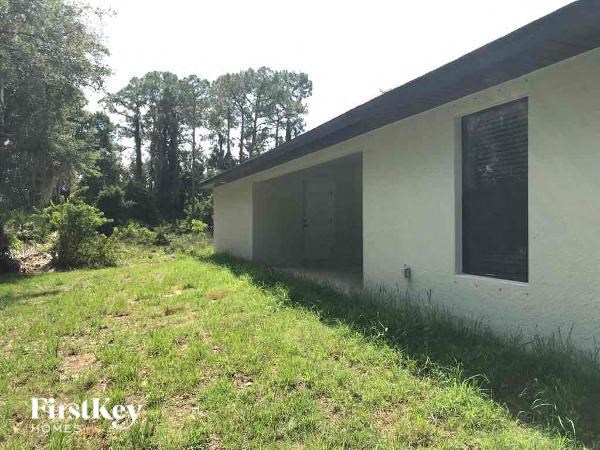 the side of a house with the grass in front of it