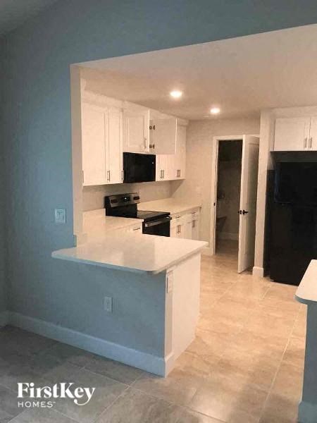 an empty kitchen with a white counter top