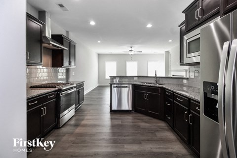 A modern kitchen with dark wood cabinets and stainless steel appliances.