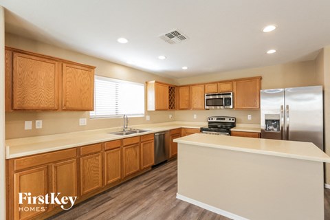 A kitchen with wooden cabinets and a refrigerator.