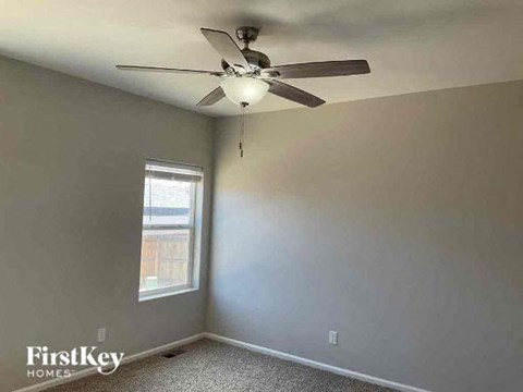 a white room with a ceiling fan and a window