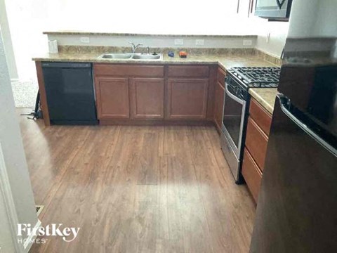 a kitchen with wooden floors and a stove and a sink