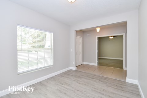 a living room with a large window and a door to a hallway