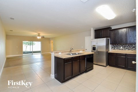 a kitchen with an island and a stainless steel refrigerator