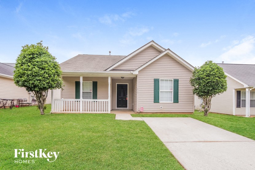 a white house with green shutters and a sidewalk