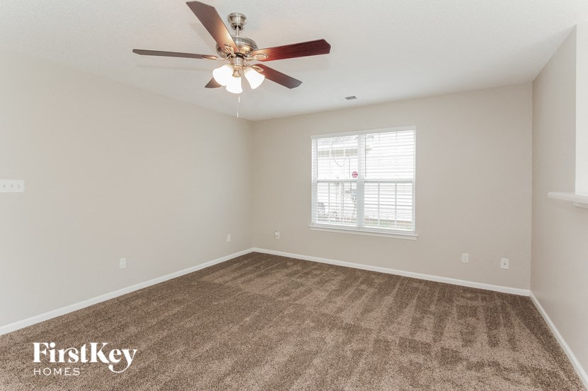 an empty room with a ceiling fan and a window