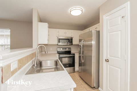 a kitchen with stainless steel appliances and white cabinets