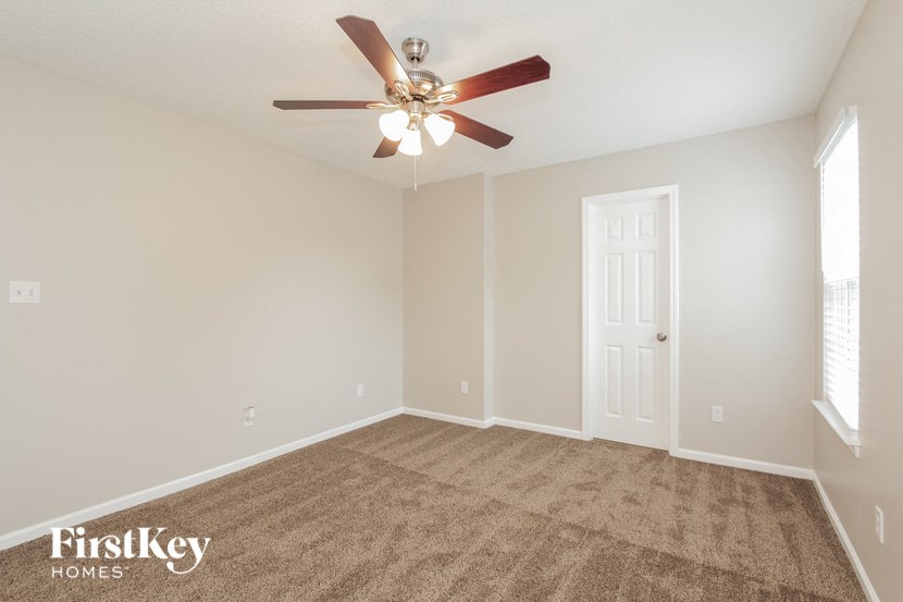 an empty living room with a ceiling fan